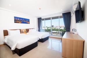 ein Hotelzimmer mit zwei Betten und einem Fernseher in der Unterkunft IU Hotel Donmueang Airport in Ban Don Muang + 99 Fotos