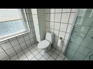 un bagno bianco con wc e doccia di Plads til børnefamilien i hjertet af Esbjerg a Esbjerg