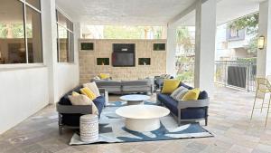 a living room with couches and a table at Relaxing Pool-View 1BR Near Top Houston Spots in Houston