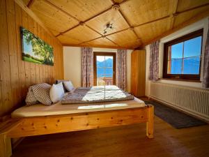 een slaapkamer met een bed in een houten kamer bij Hochleiten-Gut in Niedernsill
