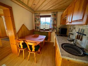 een kleine keuken met een houten tafel en stoelen bij Hochleiten-Gut in Niedernsill