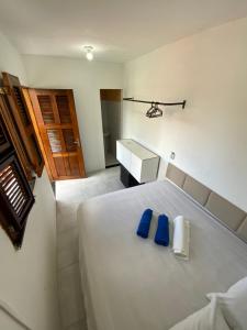 een slaapkamer met een groot wit bed met blauwe kussens bij Lindo, simples, aconchegante e pé na areia in Fortaleza