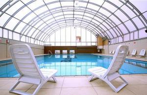 two chairs sitting in front of a swimming pool at Cerkezkoy Business Hotel in Cerkezkoy