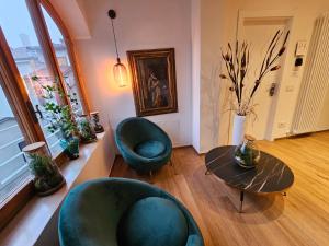 a living room with two chairs and a table at Salotto Corso Garibaldi in Piacenza +117 photos