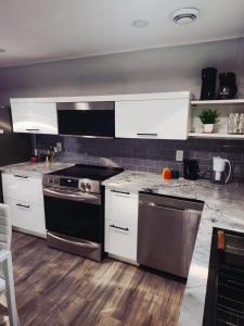 eine Küche mit weißen Schränken und einem Herd mit Backofen in der Unterkunft Walkerville Luxury Apt -River Views & Balcony in Windsor + 11 Fotos