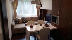 sala de estar con sofá, mesa y sillas en Lozenets Apartment en Sofía