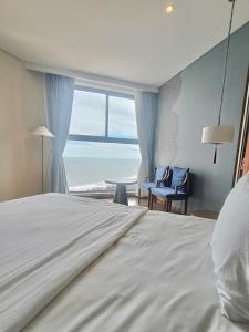 ein Schlafzimmer mit Bett und Meerblick in der Unterkunft The Moonlight Apartment- Mandala Mui Ne in Ấp Thiẹn Ái