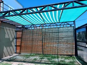 een metalen pergola boven een houten muur bij Amageu in San Luis