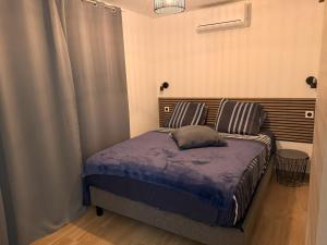 een slaapkamer met een bed met een blauw dekbed bij Le Plumeria in Saint-Pierre