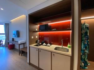 eine Küche mit Spüle und darüberliegender Mikrowelle in der Unterkunft The Moonlight Apartment- Mandala Mui Ne in Ấp Thiẹn Ái