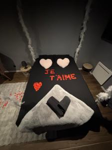 a bedroom with a bed with hearts on it at Suite Spa Privatif & Jacuzzi XXL route des vins à Chatenois in Châtenois