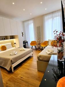 a bedroom with two beds and a table and chairs at Salotto Corso Garibaldi in Piacenza