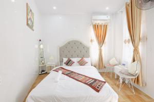 a white bedroom with a bed and a window at Huế Silk Homestay in Cồn Giả Viên