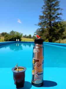 a drink in a cup next to a bottle of coffee at Hostel Ruta76 in Sierra de la Ventana