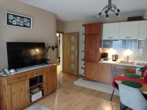 a kitchen with a flat screen tv and a dining table at W Krakowie u Helenki in Krakow