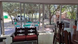 a living room with a couch in front of a window at Bosquesito in Mina Clavero