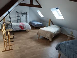 een zolderkamer met 2 stapelbedden en een trap bij Maison Le Platier d'Oye in Oye-Plage