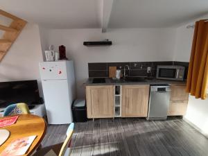 een keuken met een witte koelkast en een tafel bij Maison Le Platier d'Oye in Oye-Plage