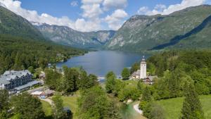 een luchtzicht op een resort met een meer en bergen bij Bohinj - Old Village House in Bohinj