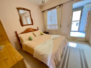 ein Schlafzimmer mit einem Bett mit Spiegel und Fenster in der Unterkunft Casa Sol y Paz in El Campello