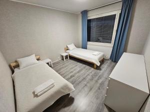 een kleine kamer met twee bedden en een raam bij Lappi in Tornio