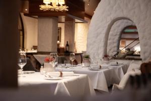 een eetkamer met tafels met witte tafels bij Mühl Vital Resort in Bad Lauterberg