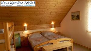 een slaapkamer met een bed en een houten wand bij Haus Karoline FeWo5 in Hochrindl