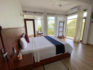 een slaapkamer met een bed en een groot raam bij Hotel H2O in Gampola +59 foto's