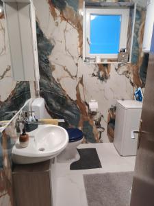 un bagno con lavandino, WC e specchio di Holiday home Ivano a Korenica