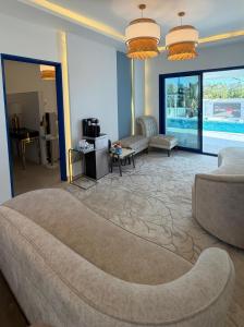 een woonkamer met een bank en een woonkamer met een zwembad bij Santorini check in in Ras al Khaimah +22 foto's