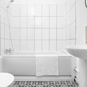 a white bathroom with a tub and a sink at Spacious Apartment - Parking - Smart TV - Netflix 9PC in Wolverhampton