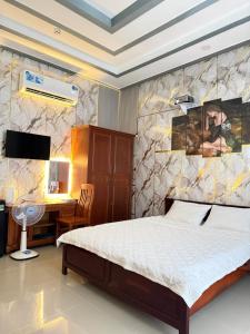 a bedroom with a bed and a desk at Motel Long Thành Quang in Long Thành