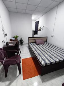 een slaapkamer met een bed, een bureau en een stoel bij TN Travel Inn - Katunayake in Katunayaka