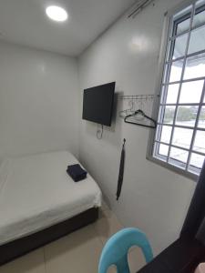 a bedroom with a bed and a tv and a chair at comfortpahlawan in Sibu +62 photos