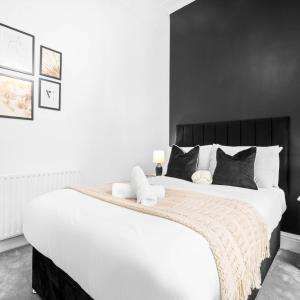 a bedroom with a large white bed with black walls at Spacious Apartment - Parking - Smart TV - Netflix 9PC in Wolverhampton +22 photos