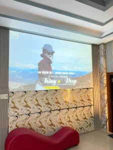 a large screen in a room with a red couch at Motel Long Thành Quang in Long Thành