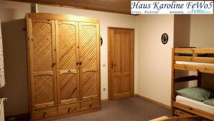 a room with a bunk bed and a wooden closet at Haus Karoline FeWo5 in Hochrindl