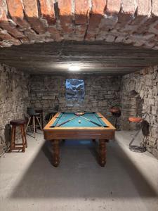 a pool table in a room with a stone wall at Conacul Fluturilor in Sinaia