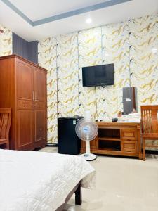 a bedroom with a bed and a tv on a wall at Motel Long Thành Quang in Long Thành