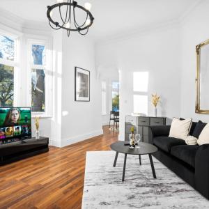 a living room with a black couch and a tv at Spacious Apartment - Parking - Smart TV - Netflix 9PC in Wolverhampton