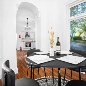 a dining room with a table with a bottle of wine at Spacious Apartment - Parking - Smart TV - Netflix 9PC in Wolverhampton