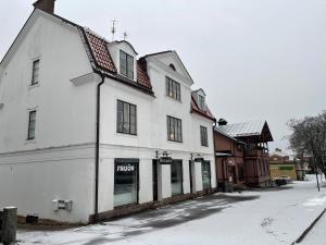 ein weißes Gebäude am Straßenrand in der Unterkunft Spacious and charming apartment in central Storvik in Storvik