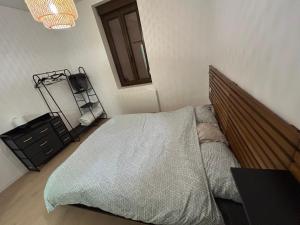 a bedroom with a bed with a wooden headboard and a table at Le cocon avec Terrasse in Amiens