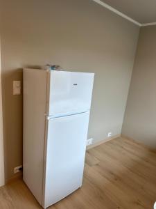 een witte koelkast in een lege kamer bij New studio centrally located in Leknes in Leknes