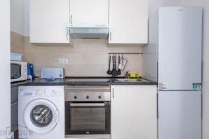 een keuken met een fornuis en een wasmachine bij Inftour President 2 Apartamento in Calpe +22 foto's
