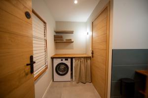 une buanderie avec une laveuse et une sécheuse à côté d'une porte dans l'établissement Villa vue mer Cap Corse, à San-Martino-di-Lota