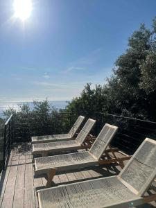 une rangée de chaises assises au-dessus d'une terrasse dans l'établissement Villa vue mer Cap Corse, à San-Martino-di-Lota