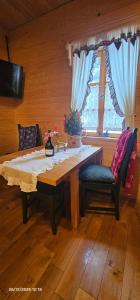 een eettafel met twee stoelen en een raam bij Vodenica Vrelo Chalets in Vrelo Koreničko