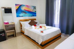 ein Schlafzimmer mit einem Bett mit Blumen darauf in der Unterkunft Island Concept Maldives in Bileffahi
