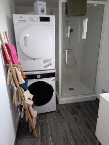 een keuken met een wasmachine en een douche bij Maison La Tour Penchée in Oye-Plage +1 foto